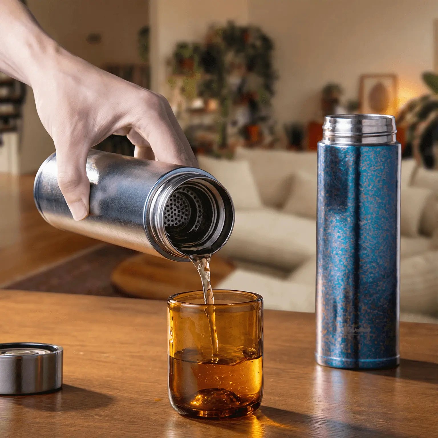 Aigrezzo titanium insulated water bottle pouring a hot drink into a glass, lightweight non-toxic titanium bottle for everyday and outdoor hydration